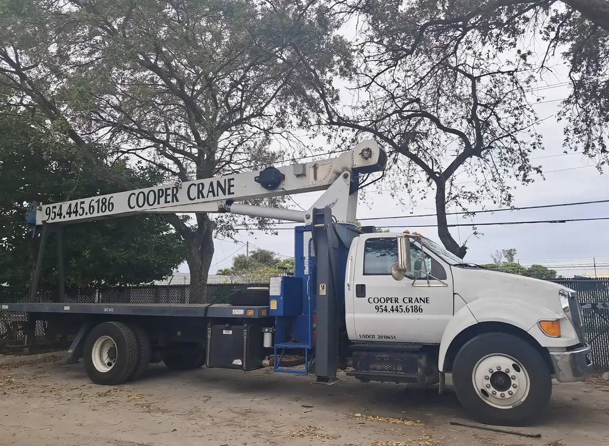 Cooper Crane boom truck lifting a fumigation tarp over a South Florida roofline