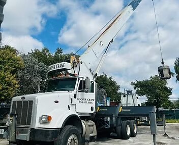 Cooper Crane Peterbilt boom truck with the boom raised and a load on the hook
